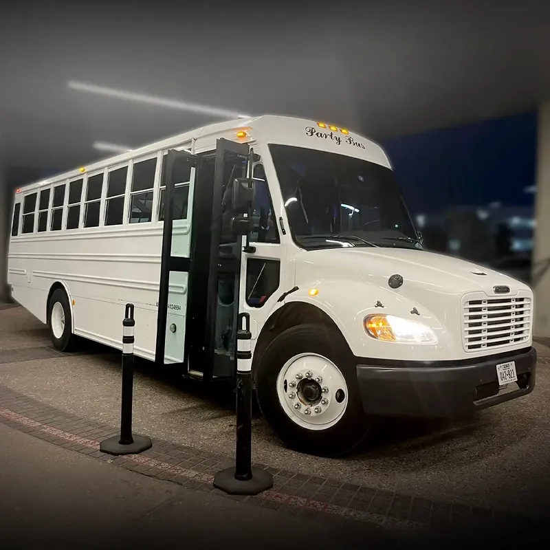 White shuttle bus with open door parked, ready for boarding.