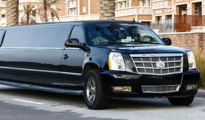 Black limousine parked near a building.